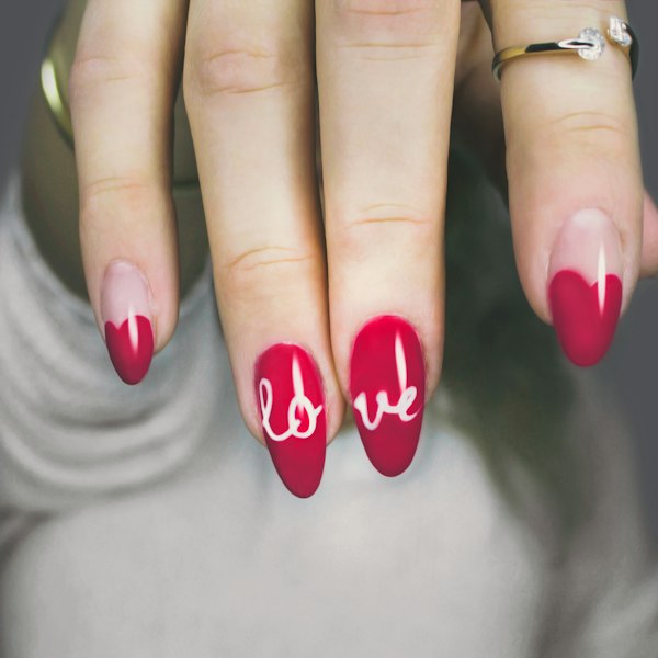 Red nails with the word love written across them